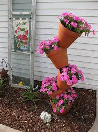 A Look That Wouldn't Be Out of Place in Alice's Wonderland  #verticalgardeningforbeginners | Flower pot tower, Flower tower, Flower pots